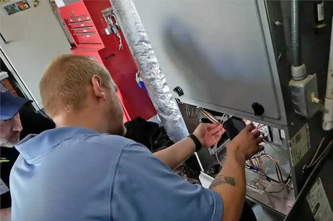 HVAC technician and Peoria homeowner review work at the furnace panel after a same-day repair